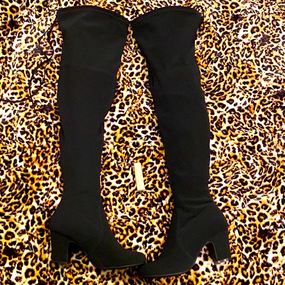 Selling a pair of knee high boots black with small heel tie in the back.